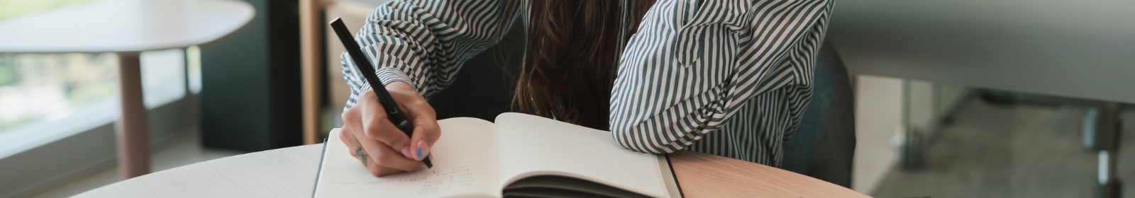 A person writing in a notebook